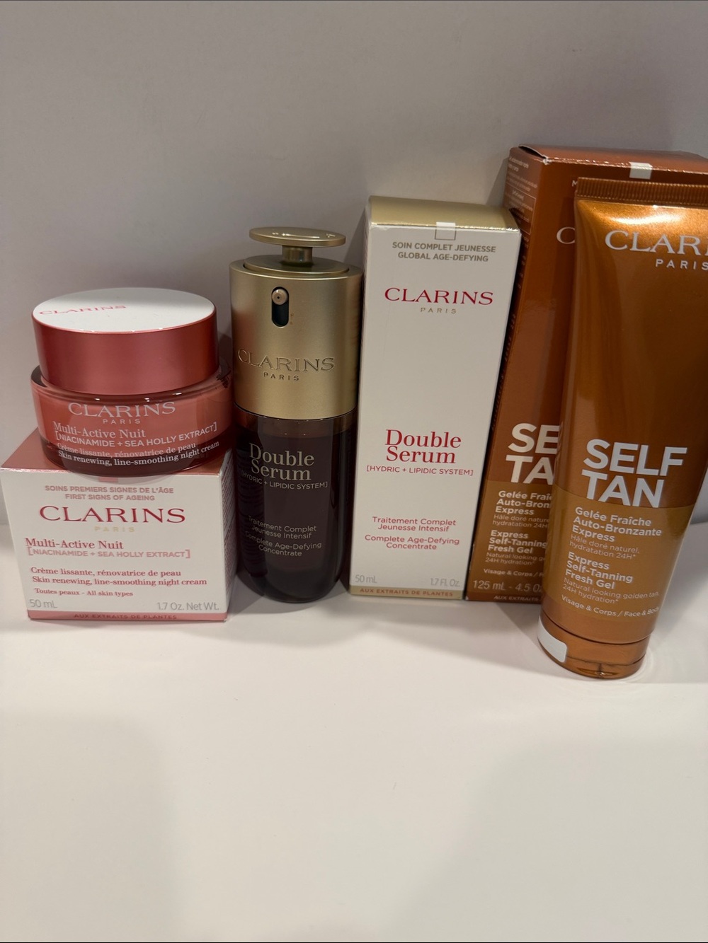 Clarins skincare set in pink, gold, white, and bronze